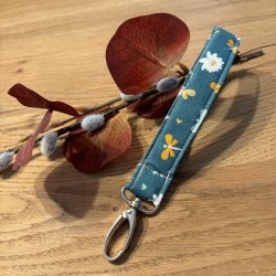 Schlüsselband mit Karabinerhaken für´s Handgelenk - petrolgrün mit weißen und orangefarbenen Blüten und Libellen